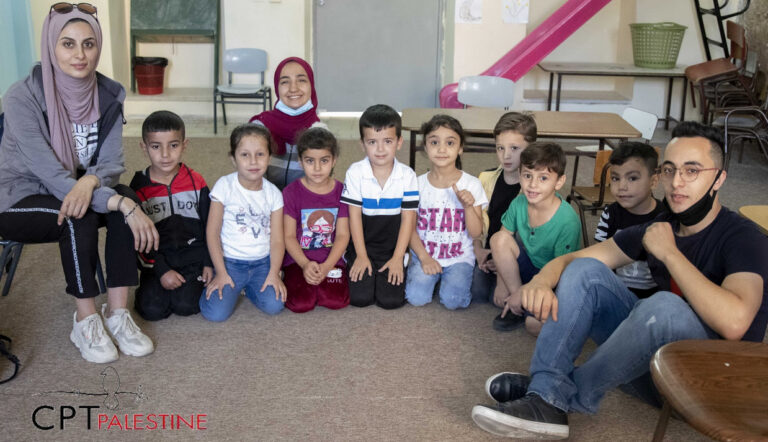 eight children and three adult sit in a semi-circle for a group photo