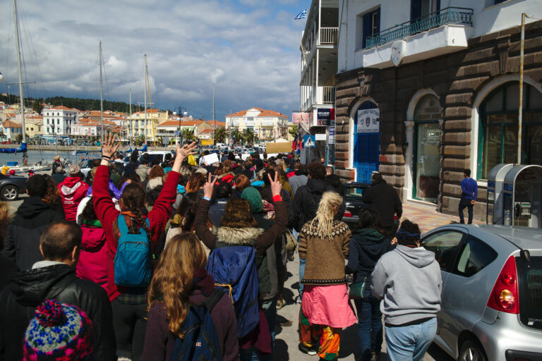 Una foto de una multitud desde atrás marchando en una manifestación en una calle