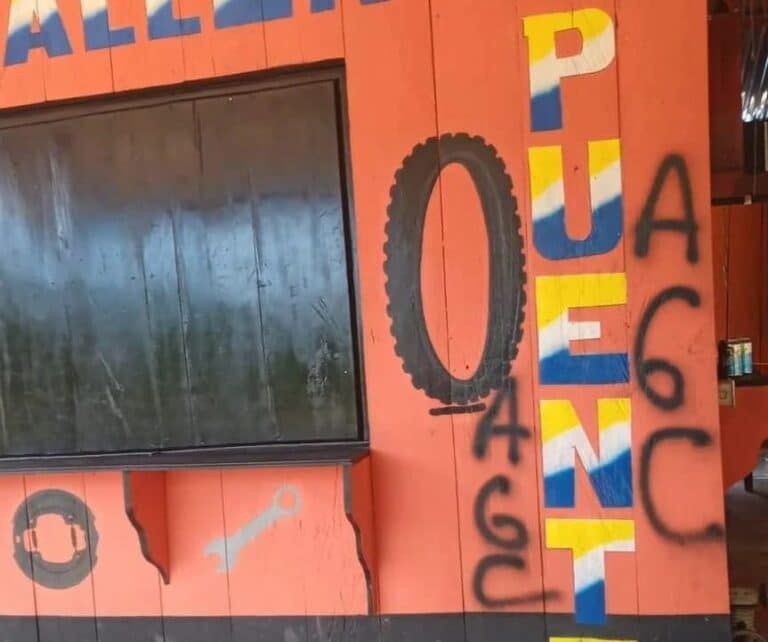 A storefront with the letters AGC spraypainted on the wall after the Clan del Golfo incursion into Segovia.