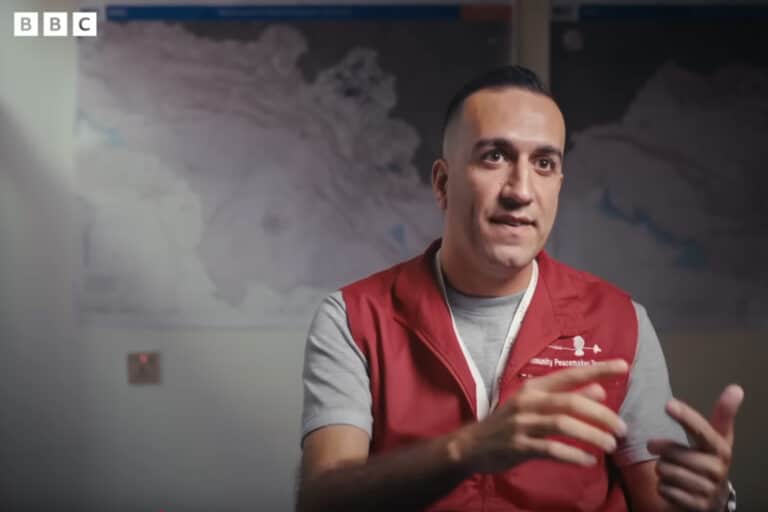 man in red jacket speaking
