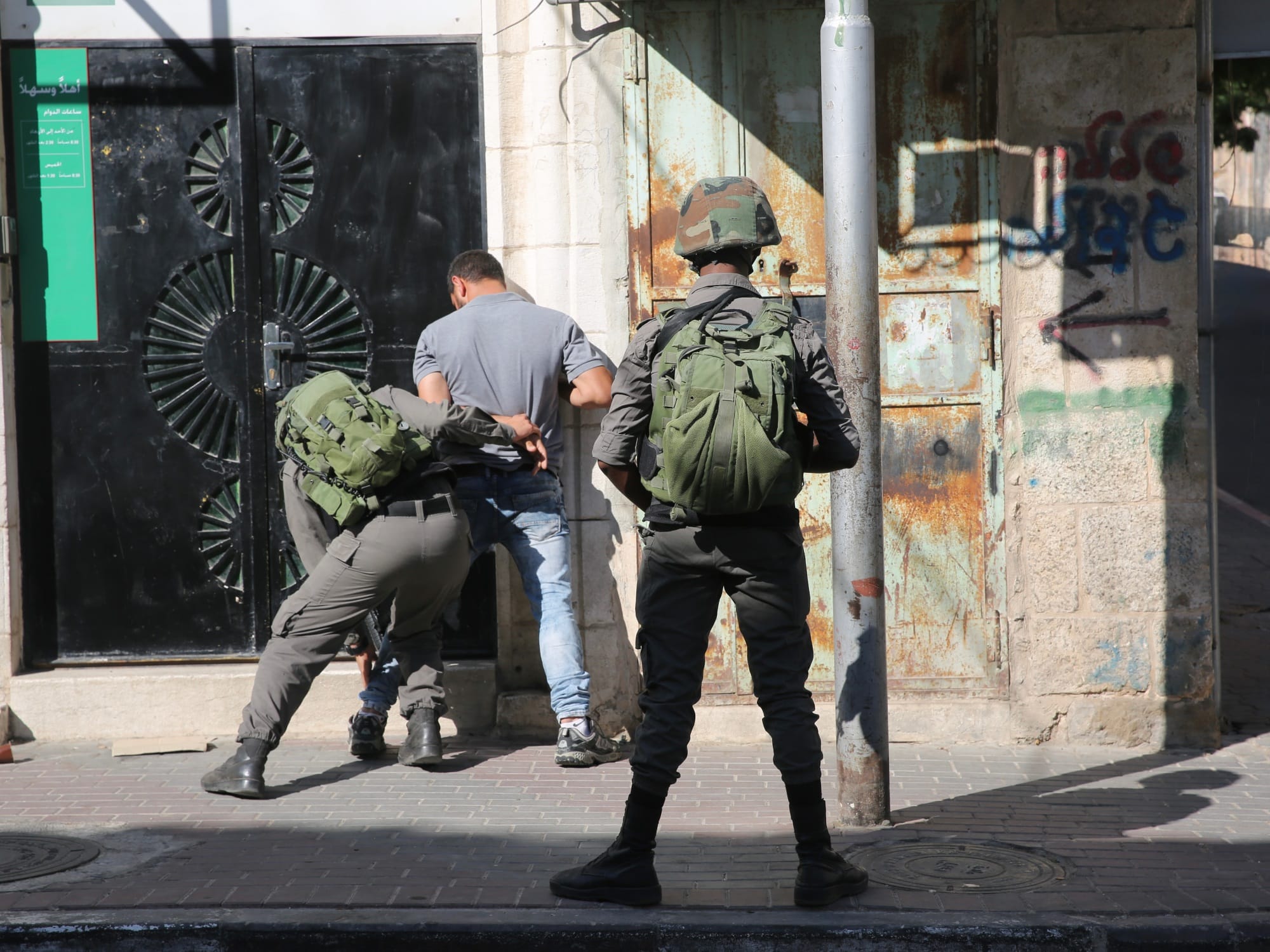 Two Israeli soldiers arrest a man