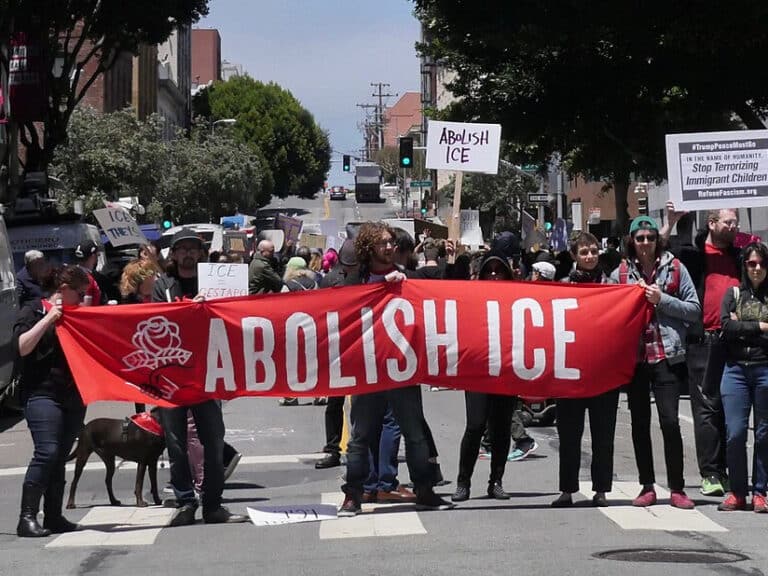 People hold a banner reading "Abolish ICE"