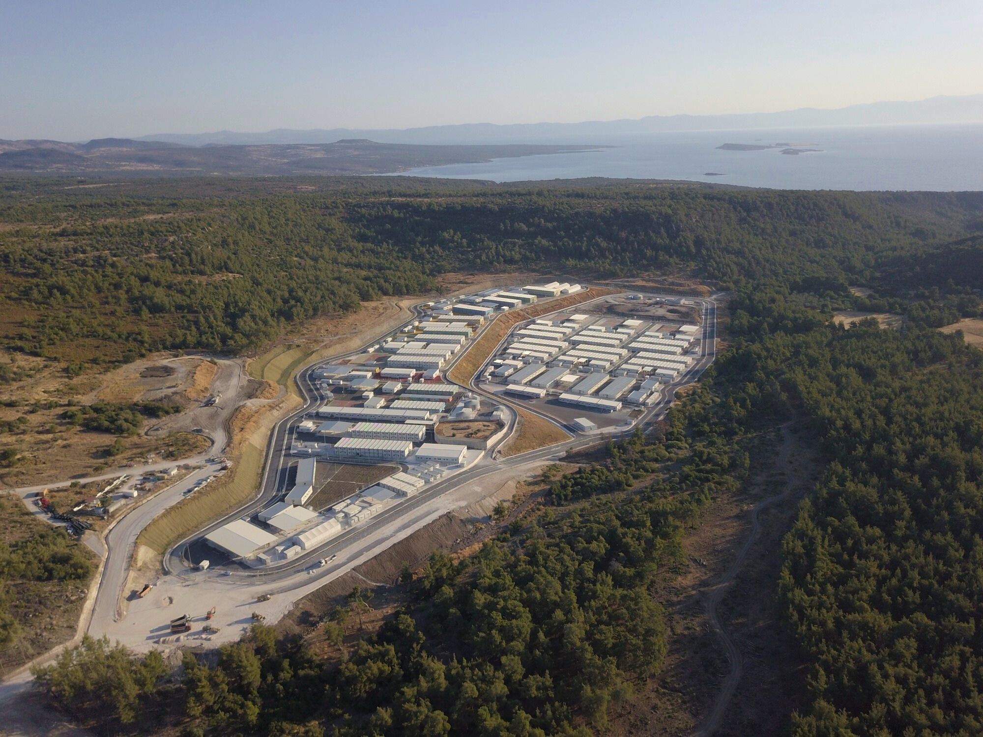 An aerial shot of a closed refugee centre, in the middle of a forest