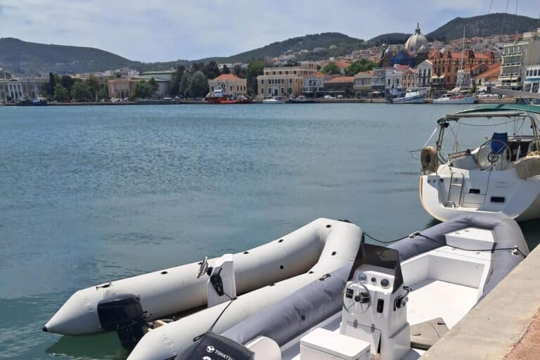 A raft in the foreground parked on a seaside port with the city in the background
