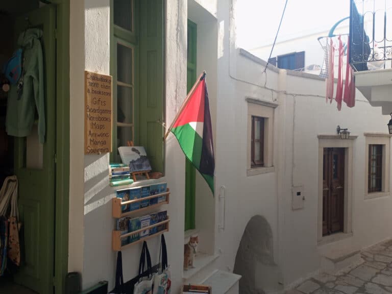 A Palestinian flag flying from a traditional Greek street
