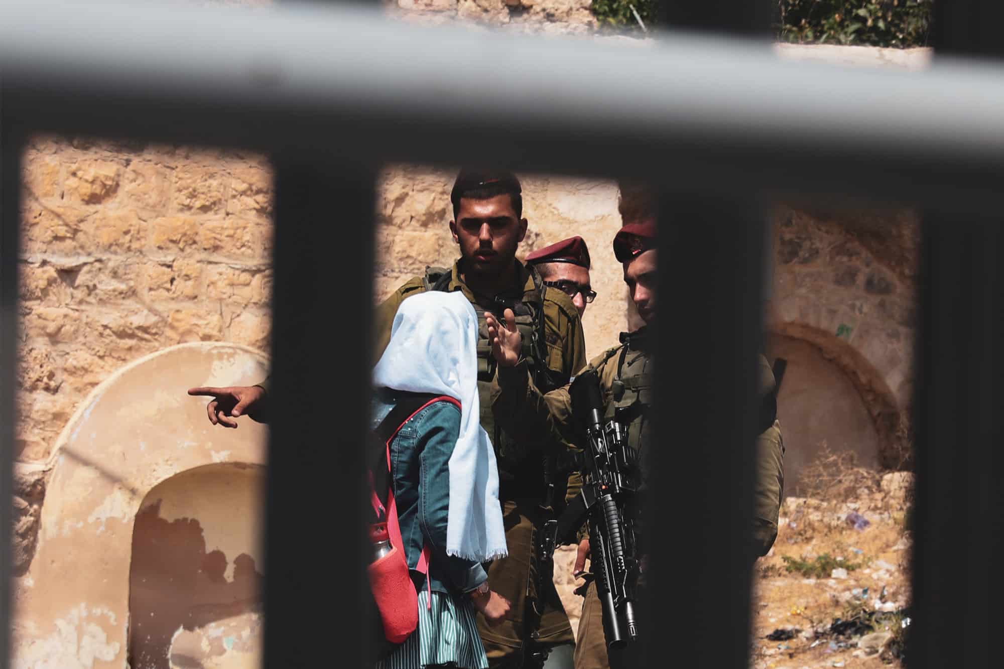 soldiers question a school girl in palestine