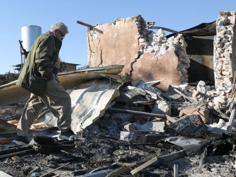 A man walks over rubble