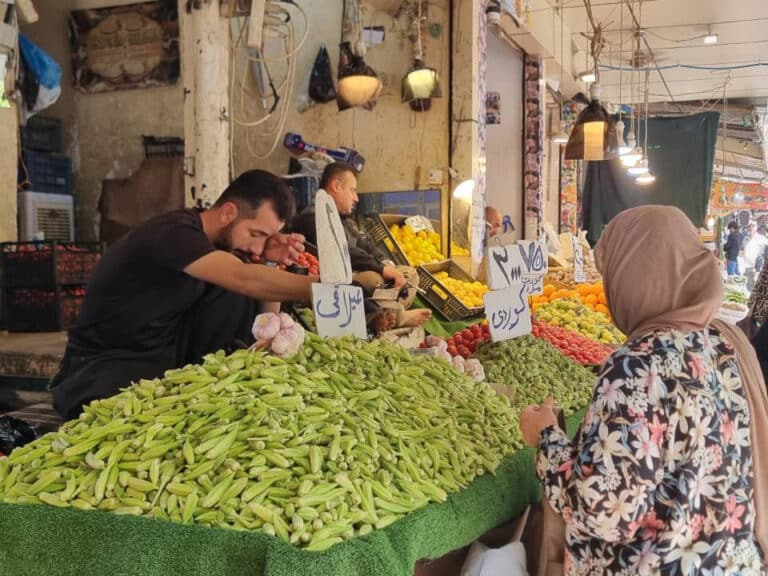 A grocer selling fresh products from a stall