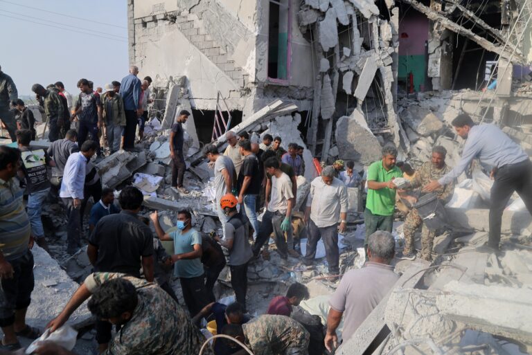 people sorting through bombed rubble