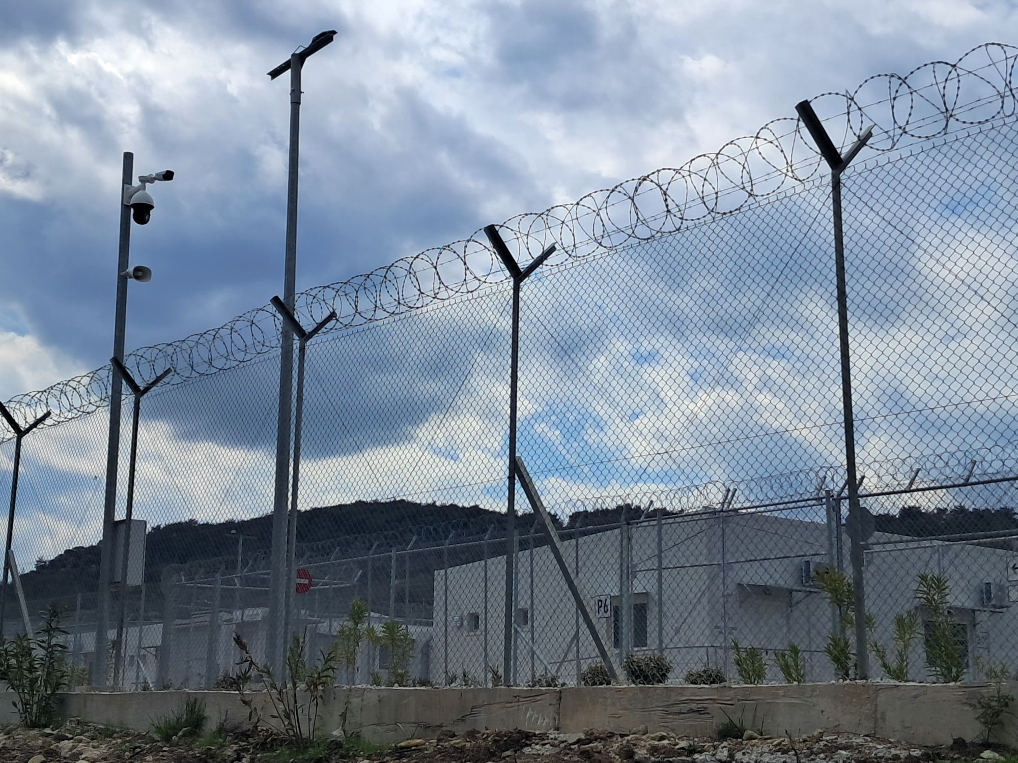 A barbed wire fence around a refugee camp