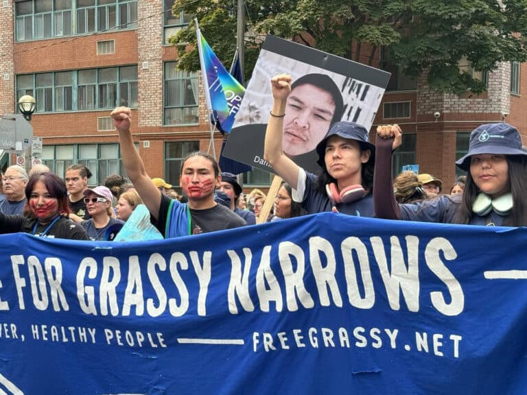 People marching behind a banner