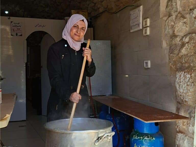 A woman stirs a cooking pot