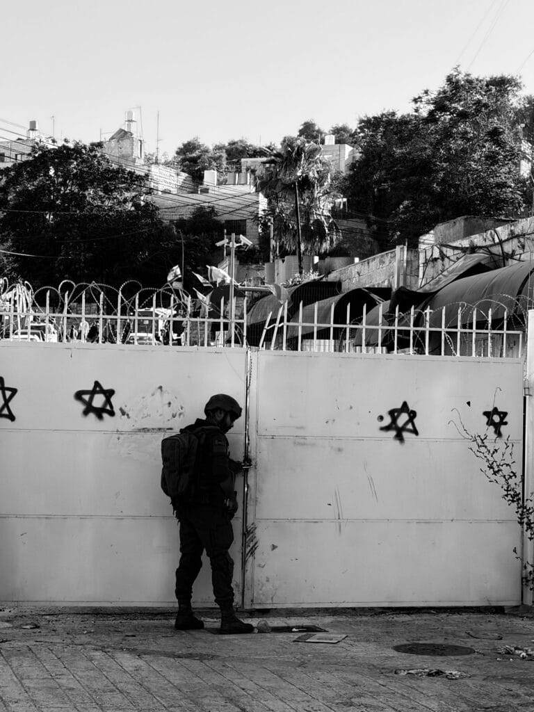 black and white imaged of IOF soldier locking a gate