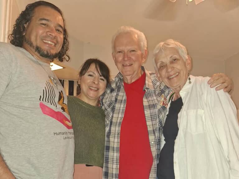 four people embrace for a group picture