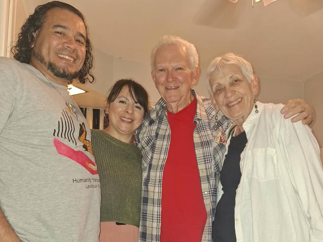 four people embrace for a group picture