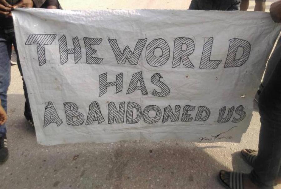 Banner at demonstration at Moria that reads 'the world has abandoned us.'